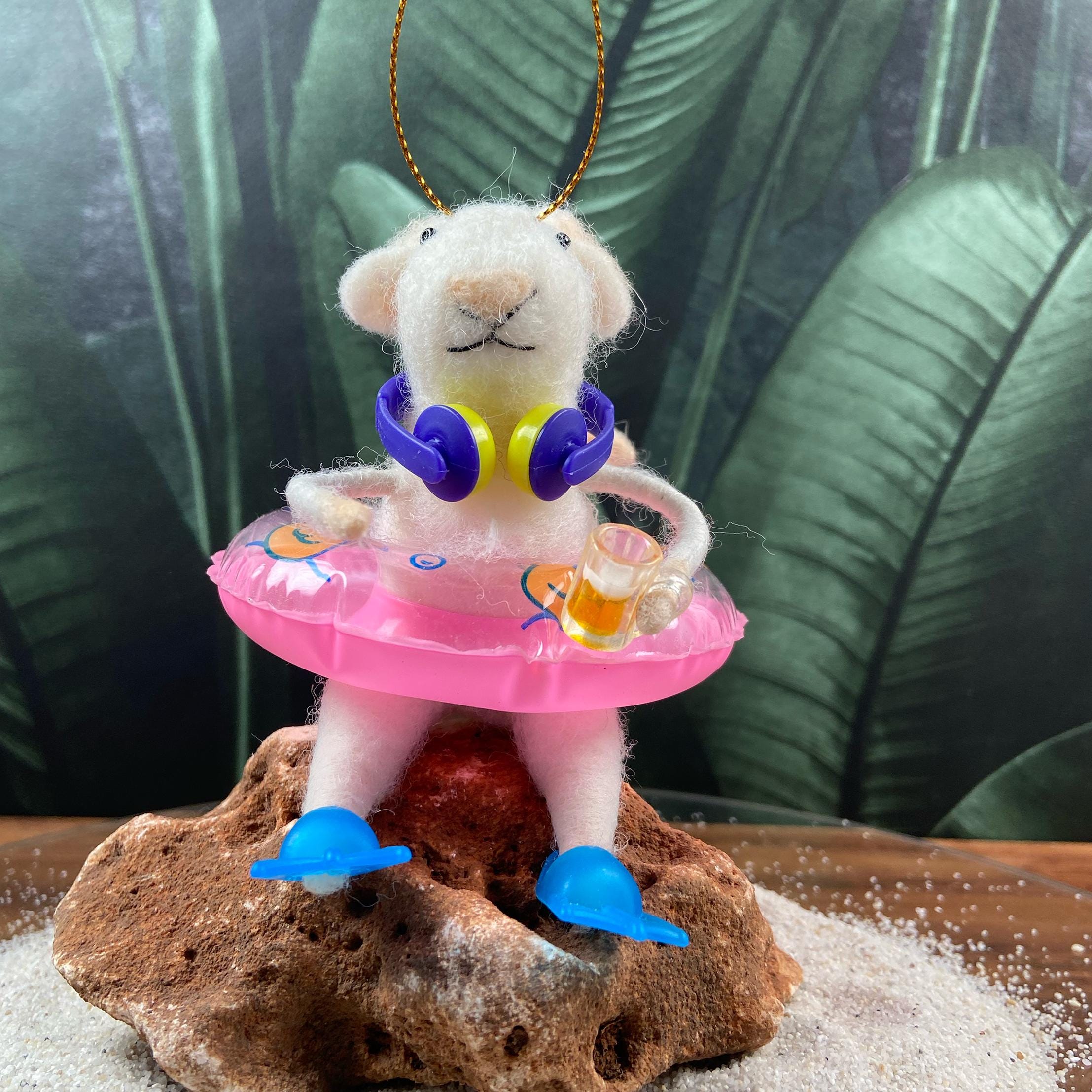 Filzmaus mit Schwimmring, Kopfhörern, einem Bierkrug in der Hand und blauen Flossen