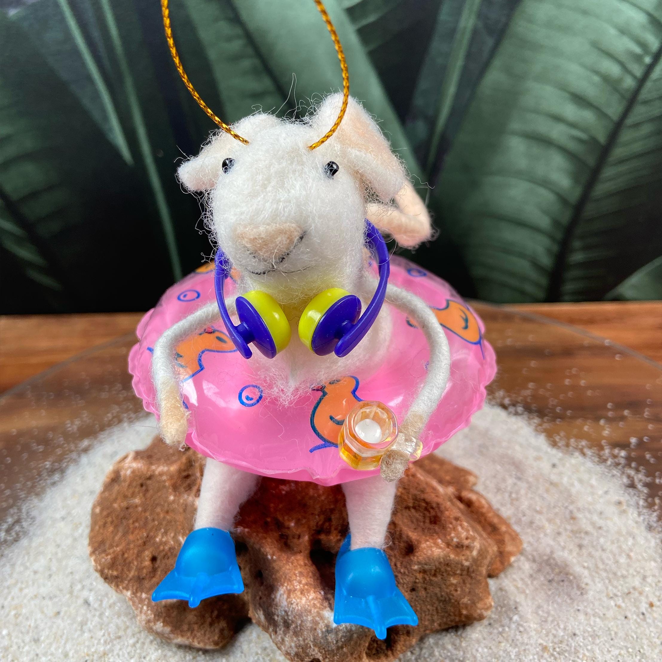 Filzmaus mit Schwimmring, Kopfhörern, einem Bierkrug in der Hand und blauen Flossen